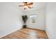 Cozy bedroom with wood-look floors, a ceiling fan, and a window providing neighborhood views at 7777 E 23Rd Ave # 203, Denver, CO 80238