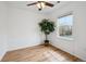 Sunny bedroom features wood-look floors, a ceiling fan, and a large window at 7777 E 23Rd Ave # 203, Denver, CO 80238
