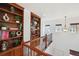 Upstairs hallway featuring custom built-in bookshelves and wood railing at 7777 E 23Rd Ave # 203, Denver, CO 80238