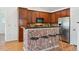Modern kitchen with cherry cabinets, granite countertops, stainless appliances, and breakfast bar at 7777 E 23Rd Ave # 203, Denver, CO 80238