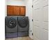 Practical laundry room featuring washer and dryer with upper cabinets at 7777 E 23Rd Ave # 203, Denver, CO 80238