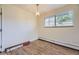 Cozy bedroom features wood floors, a pendant light, and a large window at 5995 W Hampden Ave # 2G, Denver, CO 80227