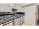 Modern kitchen with granite countertops, white cabinets, and stainless steel appliances at 5995 W Hampden Ave # 2G, Denver, CO 80227