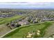 An aerial view showing the property's location, surrounded by well-maintained golf courses and lush greenery at 16485 E 117Th Ave, Commerce City, CO 80022