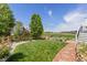 A beautifully landscaped backyard with lush grass, trees and a wooden fence, offers a peaceful outdoor retreat at 16485 E 117Th Ave, Commerce City, CO 80022