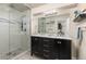 Modern bathroom with dual sinks, granite countertops, a glass-enclosed shower, and stylish tile work at 16485 E 117Th Ave, Commerce City, CO 80022