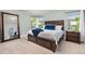Primary bedroom featuring a wooden bed frame, carpet, and views from two windows at 16485 E 117Th Ave, Commerce City, CO 80022