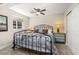 Cozy bedroom with iron bed frame, bedside lamps, neutral colors and plenty of natural light from the window at 16485 E 117Th Ave, Commerce City, CO 80022