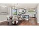 Bright kitchen with a cozy dining area, white cabinets, a kitchen island, and hardwood floors at 16485 E 117Th Ave, Commerce City, CO 80022