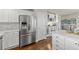 Kitchen featuring stainless steel refrigerator, white cabinets, and hardwood floors at 16485 E 117Th Ave, Commerce City, CO 80022