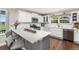 Bright kitchen featuring white cabinets, stainless steel appliances, quartz countertops, and wood floors at 16485 E 117Th Ave, Commerce City, CO 80022