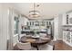Well-lit kitchen and dining area with white cabinets, modern lighting, and hardwood floors at 16485 E 117Th Ave, Commerce City, CO 80022