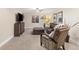 Cozy living room features carpet, TV, comfortable seating, and natural light from a small window at 16485 E 117Th Ave, Commerce City, CO 80022