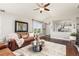 Comfortable living room featuring a plush sofa, hardwood floors, and open access to the kitchen at 16485 E 117Th Ave, Commerce City, CO 80022