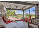 Outdoor patio features two swinging chairs, seating area, and a view of the green field and landscaping at 16485 E 117Th Ave, Commerce City, CO 80022