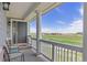 Inviting covered porch with outdoor seating and a picturesque view of the green golf course beyond at 16485 E 117Th Ave, Commerce City, CO 80022
