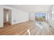 Bright living room with wood floors and lots of natural light from windows and sliding glass door at 230 Lark Sparrow Way, Bennett, CO 80102