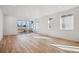 Bright living room with wood floors, large windows, and sliding glass door at 230 Lark Sparrow Way, Bennett, CO 80102