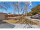 Landscaped backyard featuring a wooden fence, firepit, and a relaxing hammock at 1027 Norfolk St, Aurora, CO 80011