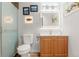 This bathroom features a glass shower, wood cabinets, and modern light fixtures at 1027 Norfolk St, Aurora, CO 80011