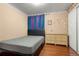 This bedroom features hardwood floors, a single bed, and a rattan dresser at 1027 Norfolk St, Aurora, CO 80011