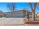 Single Gathering home with a two-car garage, brick facade, covered porch, and manicured flower beds at 1027 Norfolk St, Aurora, CO 80011