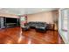 Open living room featuring hardwood floors, a black leather sectional, and entertainment center at 1027 Norfolk St, Aurora, CO 80011