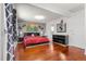 Comfortable main bedroom features hardwood floors, black furniture, and a large red bed at 1027 Norfolk St, Aurora, CO 80011