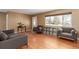 Bright living room boasting hardwood floors, gray sofas, a display cabinet, and a large window for natural light at 3150 Kassler Pl, Westminster, CO 80031