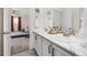 Bathroom with a double sink vanity, a mirror, and a view into the bedroom at 16108 Red Bud Loop, Parker, CO 80134