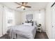 Bright bedroom featuring a ceiling fan, white walls, gray carpet, and natural light through the windows at 16108 Red Bud Loop, Parker, CO 80134