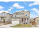 Beautiful two-story home featuring a well-kept lawn, and a modern architectural design against a bright sky at 16108 Red Bud Loop, Parker, CO 80134