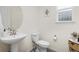 Stylish powder room with a pedestal sink, decorative mirror, and a clean, minimalist design at 16108 Red Bud Loop, Parker, CO 80134