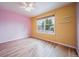 Sunlit bedroom with wood floors, bright yellow walls and large window for great natural light at 2882 Signal Creek Dr, Thornton, CO 80241