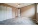 Bright bedroom features tile flooring, ceiling fan, neutral color palette and closet with folding doors at 2882 Signal Creek Dr, Thornton, CO 80241