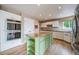 A closer view of the kitchen with white cabinets, stainless appliances, and a distinctive green kitchen island at 2882 Signal Creek Dr, Thornton, CO 80241