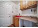 The laundry room features wood cabinets, a red utility sink, and wire rack shelving for efficient storage and organization at 2882 Signal Creek Dr, Thornton, CO 80241