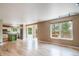 Bright open-concept living room with hardwood floors adjacent to the kitchen and access to the outdoor deck at 2882 Signal Creek Dr, Thornton, CO 80241