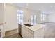 Modern kitchen with white cabinets, island with sink, and stainless steel appliances at 5553 Wisteria Ave, Firestone, CO 80504