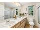 Spacious bathroom with double sinks, tile flooring, a large mirror, and framed window views at 6429 S Jamaica Cir, Englewood, CO 80111