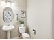 Elegant half bathroom with pedestal sink and decorative wall art at 6429 S Jamaica Cir, Englewood, CO 80111