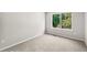 Bright bedroom with plush carpet and a large window offering a green outdoor view at 6429 S Jamaica Cir, Englewood, CO 80111