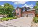 Charming brick two-story home with a manicured lawn and a two-car garage on a sunny day at 6429 S Jamaica Cir, Englewood, CO 80111