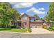 Inviting two-story brick home featuring a well-maintained lawn and convenient two-car garage at 6429 S Jamaica Cir, Englewood, CO 80111