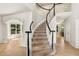 Elegant foyer showcasing a curved staircase with black and white banisters and hardwood floors at 6429 S Jamaica Cir, Englewood, CO 80111