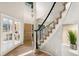 Bright foyer featuring a staircase with carpet and white railing, complemented by hardwood floors at 6429 S Jamaica Cir, Englewood, CO 80111