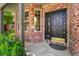 Charming front entry features a brick facade and a black front door with decorative gold hardware at 6429 S Jamaica Cir, Englewood, CO 80111