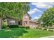 Beautiful brick home with lush green lawn and mature trees, creating an inviting curb appeal at 6429 S Jamaica Cir, Englewood, CO 80111