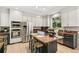 Modern kitchen featuring stainless steel appliances, granite countertops, and a center island with breakfast bar at 6429 S Jamaica Cir, Englewood, CO 80111