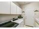 Well-lit laundry room featuring washer, dryer, storage, and tiled floor at 6429 S Jamaica Cir, Englewood, CO 80111